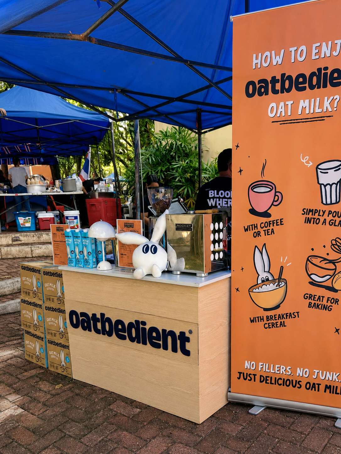 The Oatbedient booth at a food fair, with Oatdit the oat groat mascot on the counter