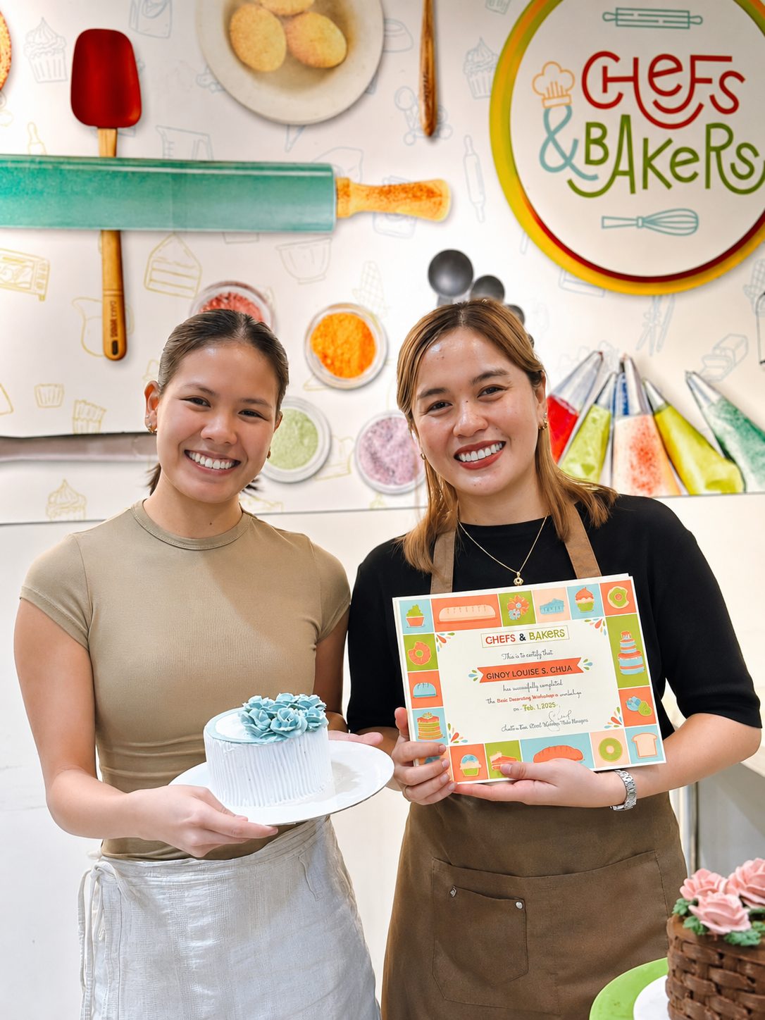 A student and instructor holding a finished cake and workshop certificate