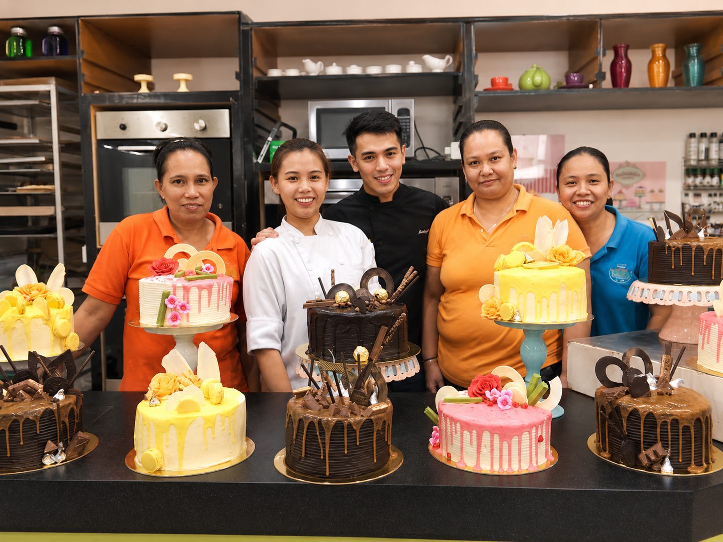 A production team with finished drip cakes